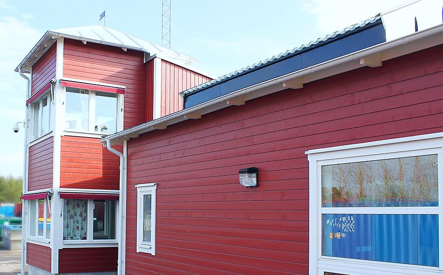 Röd byggnad på Hulje återvinningscentral.