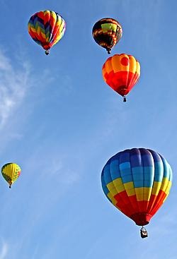 Färgglada luftballonger på en klarblå himmel