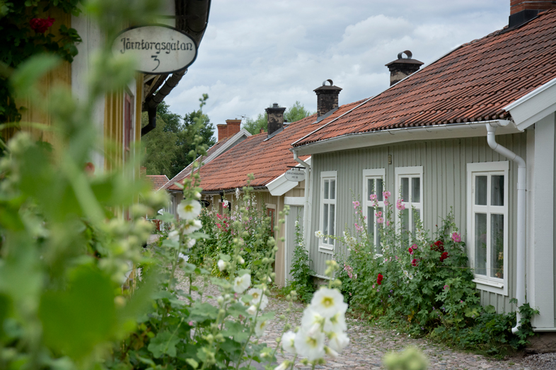 Järntorgsgatan i Skänninge, en gata med pittoreska gammla hus och massor av stockrosor.