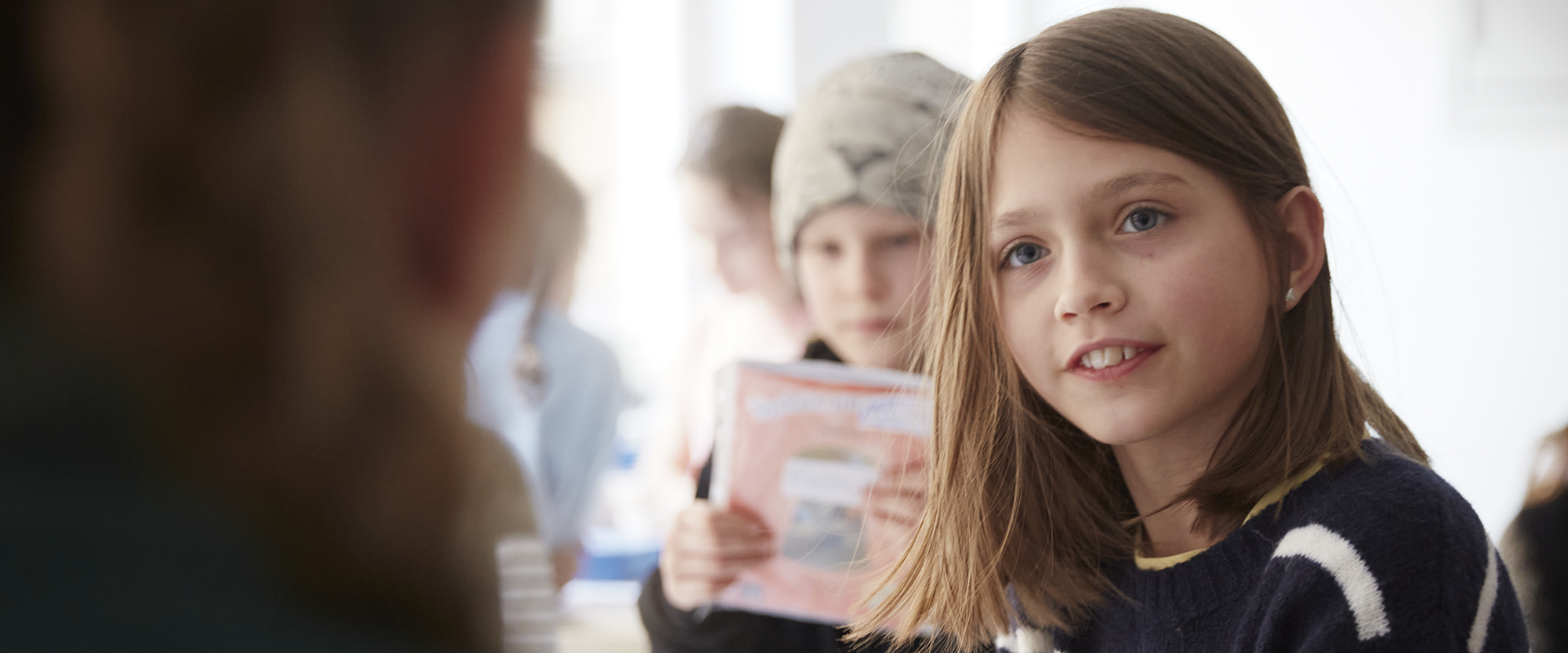 Elev tittar på lärare. Andra elever i bakgrunden.