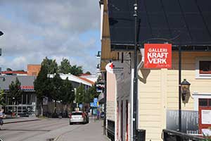 En bil står parkerad vid en butik i Mjölby innerstad