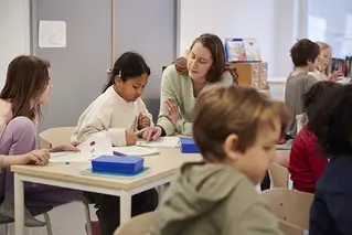 Klassrum med flera barn och en lärare.